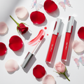 Butterfly Kisses Kiss Me Lip Gloss lifestyle flat lay with rose petals and butterflies